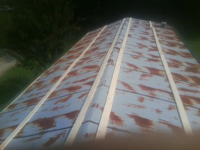Rusted metal roof panels with new wood purlins before replacement — Storm Damage Roof Repair in Hancock by Roofing Brothers