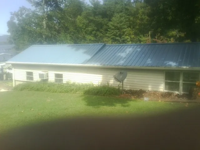 Blue metal roof running the length of a single story home in Hancock