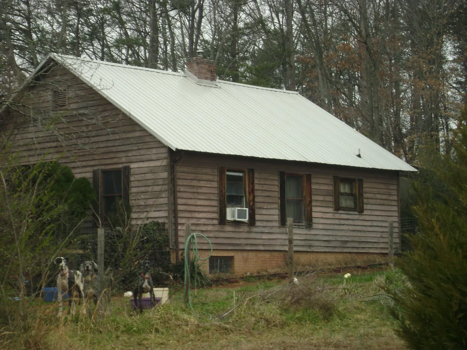 White metal roof on an old wood sided farmhouse, from a Metal Roof Installation job in Hancock